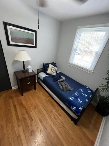a bedroom with a bed and a table and a window at Fantastic 3BR Close to Botanical Gardens and Airport in Norfolk