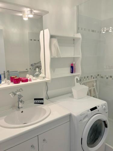 une salle de bain blanche avec une machine à laver et un lavabo dans l'établissement Appartement hypercentre avec parking, à Albi