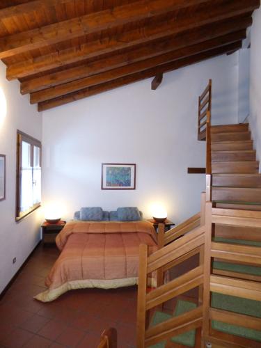a bedroom with a bed and a wooden staircase at Hotel Residence Margherita in Montecreto