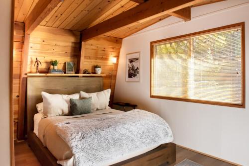 a bedroom with a bed in a room with wooden walls at Treehouse - Close to Slopes, Hot Tub, Gourmet Kitchen, Deck in Big Bear Lake