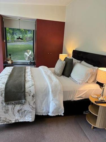 a bedroom with a large bed and a window at Daylesford Spa Villa One in Daylesford