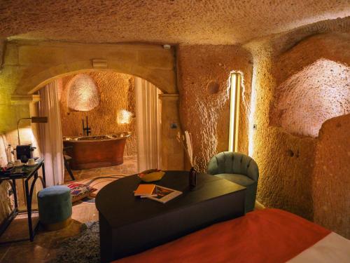 a living room with a table and a bath tub at Very Peri Cappadocia - The Lifestyle Luxury Design Hotel in Uchisar