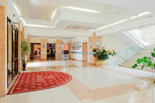 - un hall avec un tapis rouge au sol et des escaliers dans l'établissement AMAKS Park Hotel, à Tambov