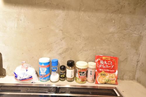 a shelf with spices and other food items on it at Dive INN Kiryu in Kiryu