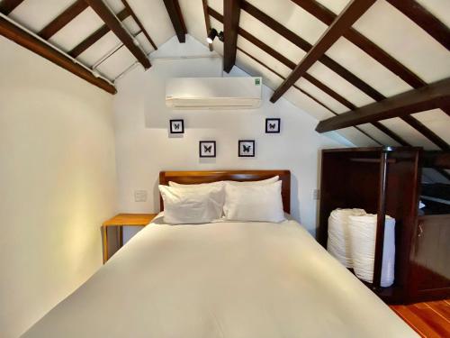 a bedroom with a large bed with white pillows at Villa Orchid Garden Riverside Hoi An in Hoi An