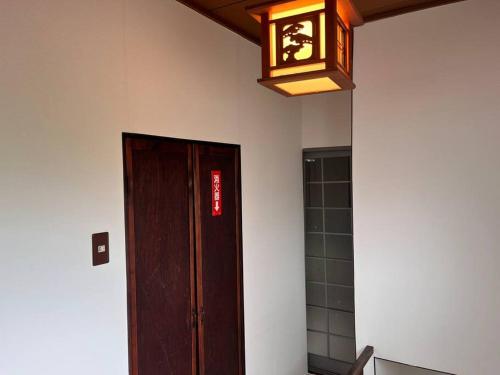 a light hanging from a ceiling next to a door at 岡山駅から徒歩7分の一軒家 in Okayama