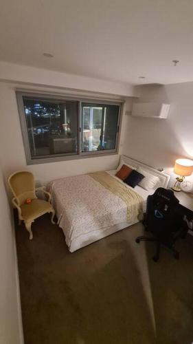 a bedroom with a bed and a chair and a window at Spacious 3 bedroom, 2 washroom and 2 parking 5 min from train station in Blacktown