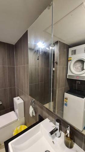 a bathroom with a sink and a washing machine at Spacious 3 bedroom, 2 washroom and 2 parking 5 min from train station in Blacktown