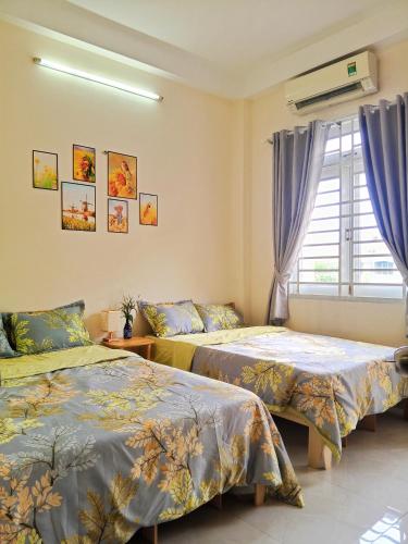 a bedroom with two beds and a window at Ola's Home in Ho Chi Minh City