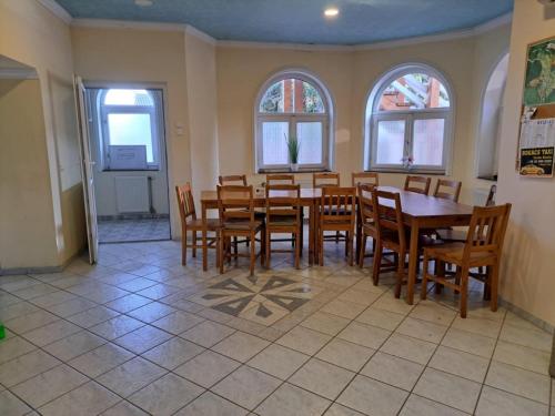 a dining room with a table and chairs and windows at Tünde Bogács in Bogács