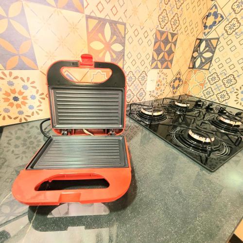 a toaster oven sitting on a counter next to a stove at Perfeito Studio 21 in Poços de Caldas