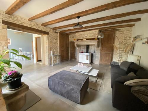 a living room with a couch and a table at Chez Odette chambre saule pleureur in Esnoms-au-Val