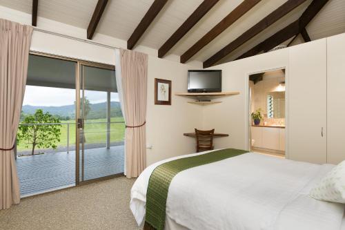 um quarto com uma cama e uma porta de vidro deslizante em Hillcrest Mountain View Retreat em Crystal Creek