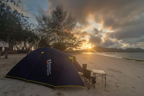 a tent on a beach with a table and chairs at Camp Gili X - Gili Tangkong Island in Pulau Gilinanggu