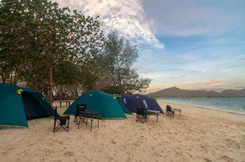 a group of tents on a sandy beach at Camp Gili X - Gili Tangkong Island in Pulau Gilinanggu