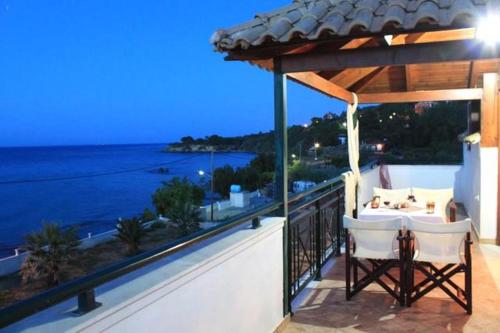 uma varanda de uma casa com uma mesa e vista para o oceano em Tonias Houses - Thea House and Vrachos Attic Appartment em Alikanás