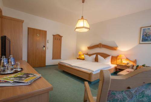 Schlafzimmer mit einem Bett, einem Schreibtisch und einem Tisch in der Unterkunft Hotel Arcus in Elsterwerda