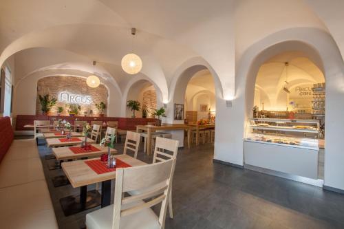 a dining room with tables and chairs in a restaurant at Hotel Arcus in Elsterwerda