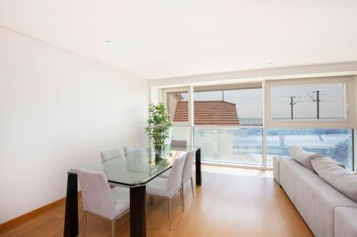a dining room with a glass table and a couch at River View Luxury Apartment in Cruz Quebrada