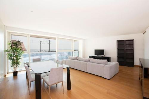 a living room with a white couch and a table at River View Luxury Apartment in Cruz Quebrada