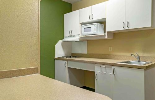 a small kitchen with a sink and a microwave at Extended Stay America Suites - Detroit - Madison Heights in Madison Heights