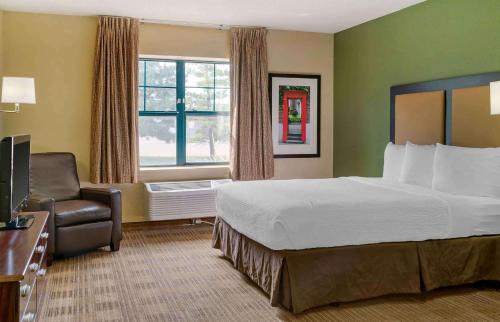 a hotel room with a bed and a chair at Extended Stay America Suites - Detroit - Madison Heights in Madison Heights