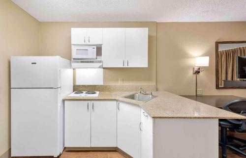 a kitchen with white cabinets and a white refrigerator at Extended Stay America Suites - Los Angeles - Chino Valley in Chino