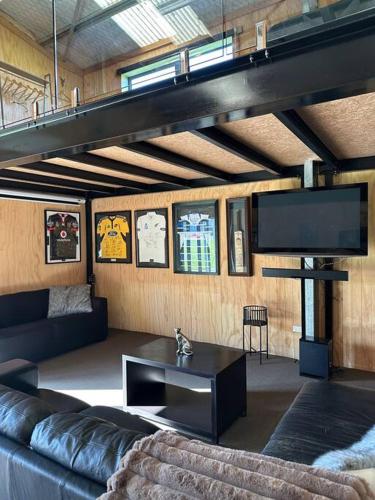 a living room with a couch and a tv at Mount Jowett Retreat in Whanganui
