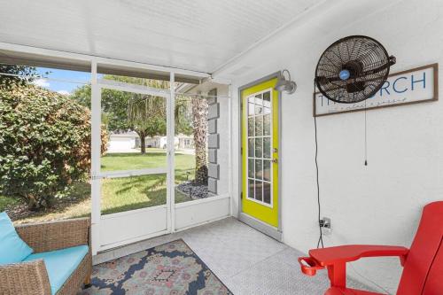 a porch with a red chair and a yellow door at Making Memories in Panama City Beach