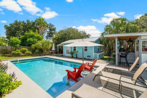 a swimming pool with chairs and a house at Making Memories in Panama City Beach