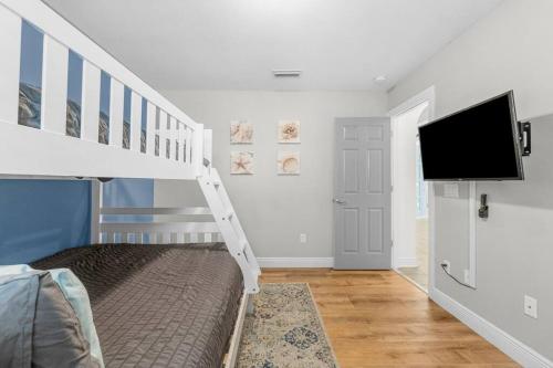 a bedroom with a bunk bed and a tv at Making Memories in Panama City Beach