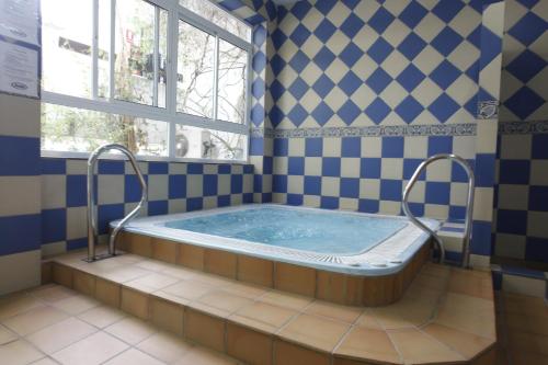 een jacuzzi in een badkamer met een raam bij Benalmadenapartments BBQ Evita Beach Club in Benalmádena