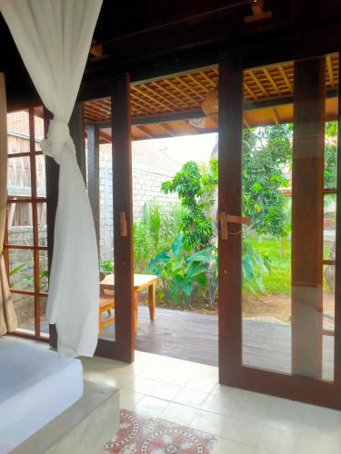 a bedroom with a door open to a patio at Vanaya Lodge in Pemuteran