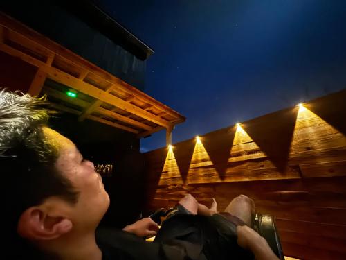 a man laying down in a chair at night at 安全第一客室 Anzen Daiichi INN in Nishiawakura