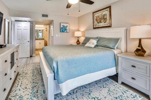 a bedroom with a bed with a blue comforter at Land's End 4-202 Bay Front - Premier in St Pete Beach