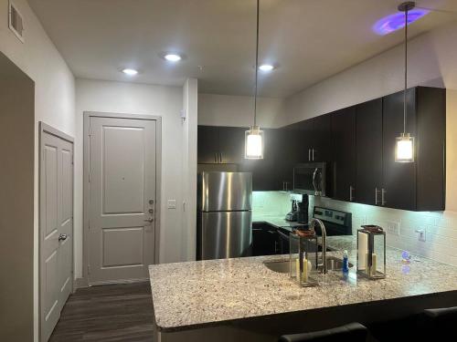 a kitchen with a sink and a refrigerator at Luxurious 1 Bedroom w pool & patio inGalleria area in Houston