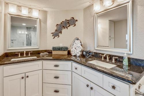 a bathroom with two sinks and two mirrors at Land's End 6-302 Beach Front - Premier in St Pete Beach