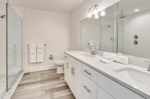 a white bathroom with two sinks and a toilet at Madeira Del Mar 305 in St Pete Beach