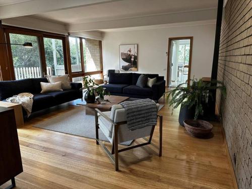 a living room with a couch and a table at Relaxed and stylish -self check in, secure parking in Mount Clear