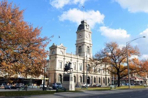 a building with a clock tower on top of it at Relaxed and stylish -self check in, secure parking in Mount Clear