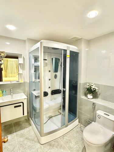 a bathroom with a shower with a toilet and a sink at LaLa Penthouse in Hue