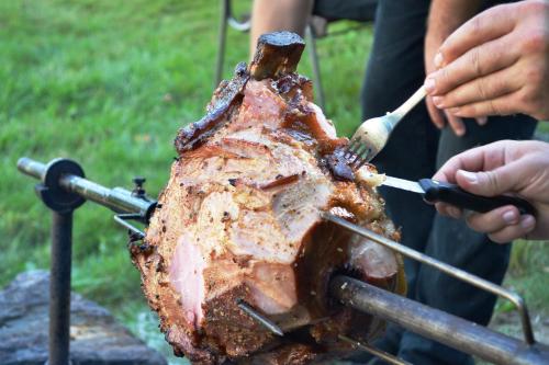 a person cooking a roast on a grill at Chalupa pod Klepáčem in Králíky