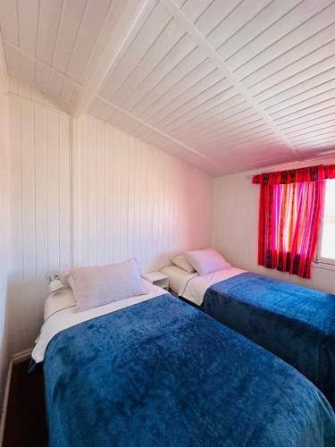 two beds sitting in a room with a window at MAKTVB - EcoLodge San Pedro de Atacama in San Pedro de Atacama