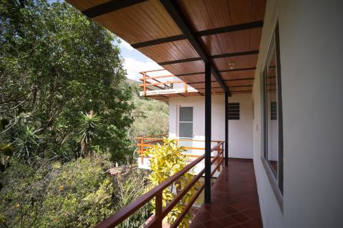 a balcony of a house with a wooden roof at HOTEL LA SELVA Reserva in La Vega