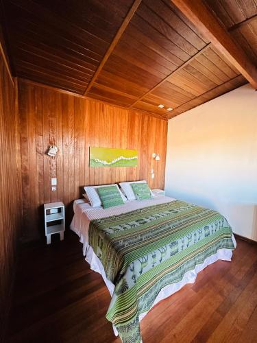 a bedroom with a bed in a wooden wall at MAKTVB - EcoLodge San Pedro de Atacama in San Pedro de Atacama