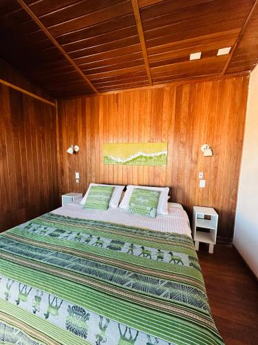 a bedroom with a large bed in a wooden wall at MAKTVB - EcoLodge San Pedro de Atacama in San Pedro de Atacama