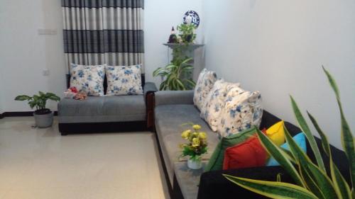 a living room with a couch and some plants at Success Villa Hikkaduwa in Hikkaduwa