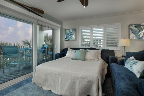 a bedroom with a bed and a couch and a balcony at Land's End 4-306 Bay Front - Premier in St Pete Beach
