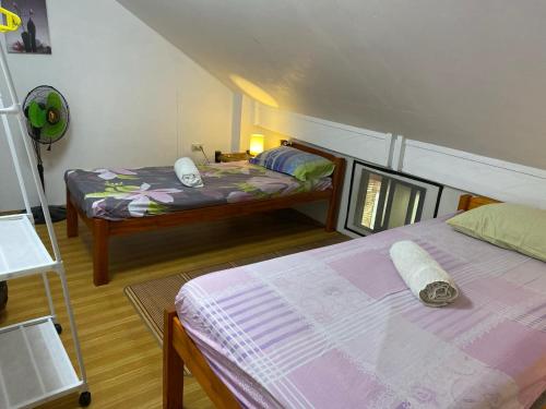 a bedroom with two beds in a room at Koa's Beach House in Tangalan