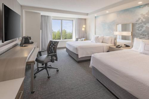 a hotel room with two beds and a desk with a computer at Courtyard by Marriott Halifax Dartmouth in Halifax